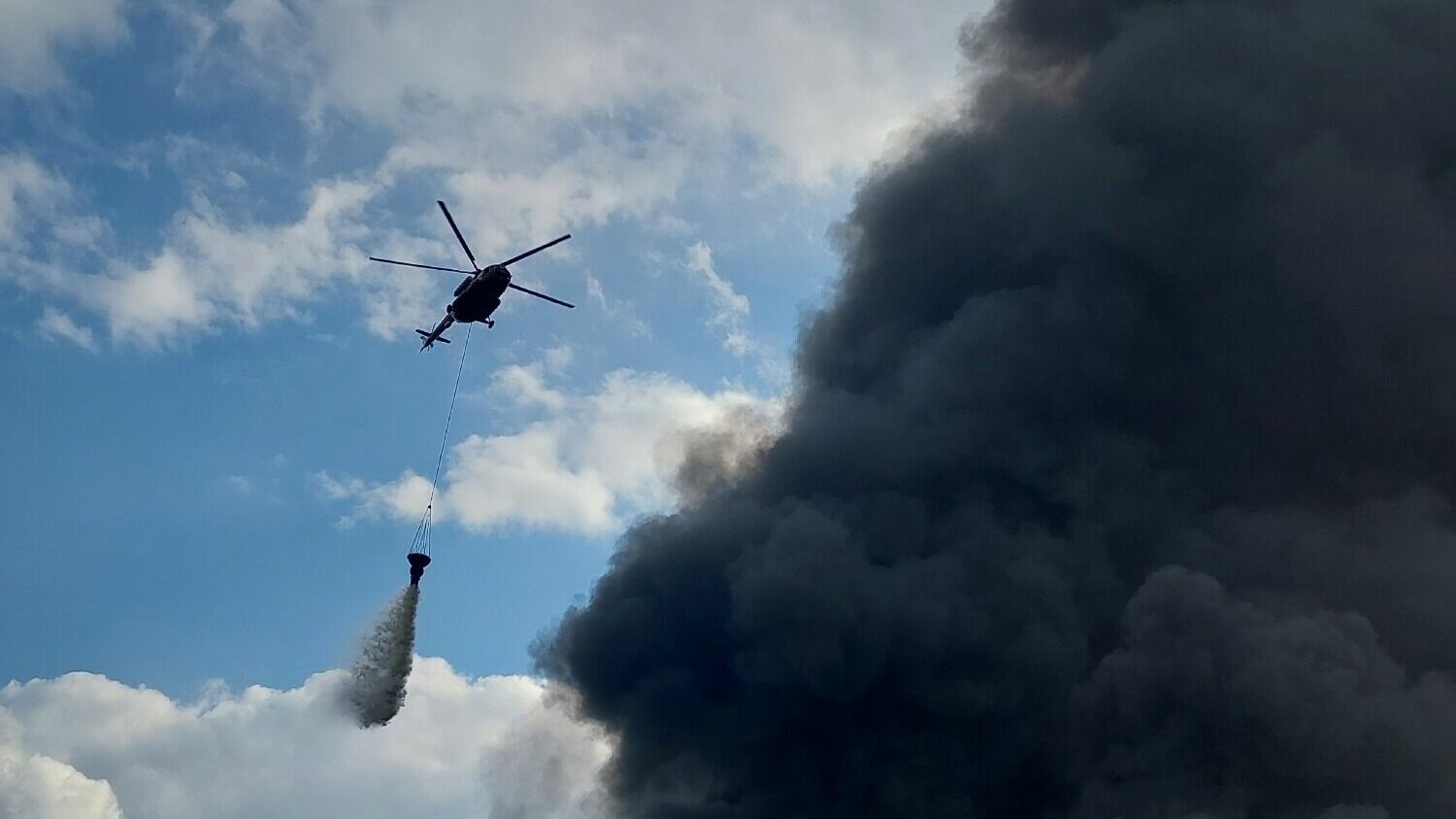 Вертолет сбрасывает воду на пожар в Дзержинске